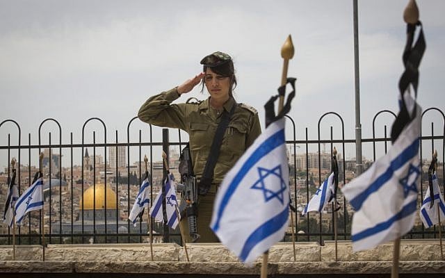Israeli soldiers salute graves of fallen Israeli soldiers at the Mount of Olives cemetery after placing flags on the graves during a ceremony in preparation for Memorial Day, beginning tonight. May 10, 2016. (Nati Shohat/Flash90)