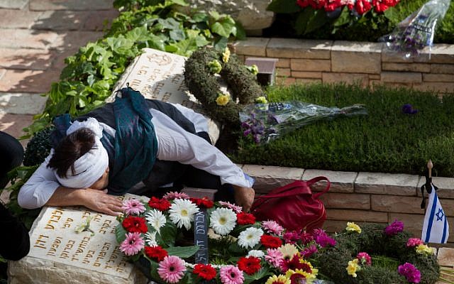 Bereaved Israelis mourn next to graves of fallen soldiers at the Mt. Herzl military cemetery in Jerusalem on Israeli Memorial Day. May 11, 2016. (Miriam Alster/Flash90)