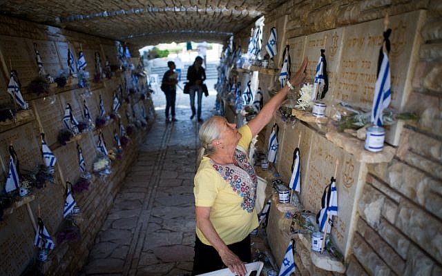 Bereaved Israelis mourn next to graves of fallen soldiers at the Mt. Herzl military cemetery in Jerusalem on Israeli Memorial Day. May 11, 2016. (Miriam Alster/Flash90)