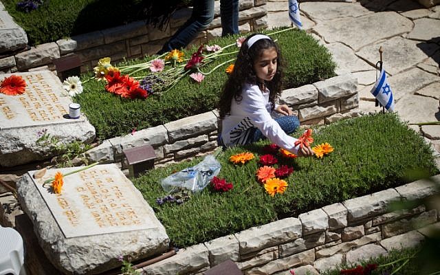 Bereaved Israelis mourn next to graves of fallen soldiers at the Mt. Herzl military cemetery in Jerusalem on Israeli Memorial Day. May 11, 2016. (Miriam Alster/Flash90)