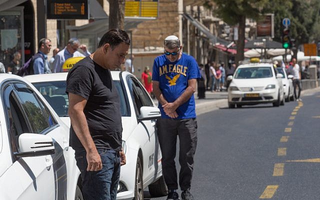 People stand still as a two-minute siren sounds across Israel, marking Memorial Day which commemorates the fallen Israeli soldiers in Jerusalem on May 11, 2016. (Nati Shohat/Flash90)