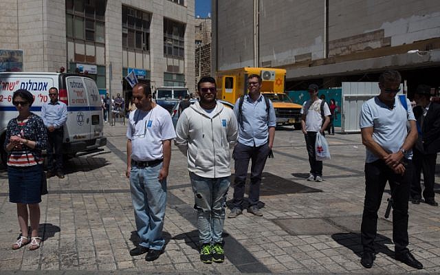 People stand still as a two-minute siren sound across Israel, marking Memorial Day which commemorates the fallen Israeli soldiers in Jerusalem on May 11, 2016.(Nati Shohat/Flash90)