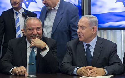 Benjamin Netanyahu, right, and Avigdor Liberman, left, sign a coalition agreement in the Knesset on May 25, 2016. (Yonatan Sindel/FLASH90)