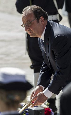 French President Francois Hollande re-kindles the eternal flame at the Tomb of the Unknown Soldier during commemorations at the Arc de Triomphe marking the 71st anniversary of the end of World War II, in Paris, France, Sunday, May 8, 2016. (AP Photo/Kamil Zihnioglu, Pool)
