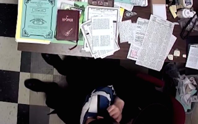A screenshot from an 11-minute video showing a Hasidic principal handling a young boy. (Screenshot from YouTube) A screenshot from an 11-minute video showing a Hasidic principal handling a young boy. (Screenshot from YouTube)