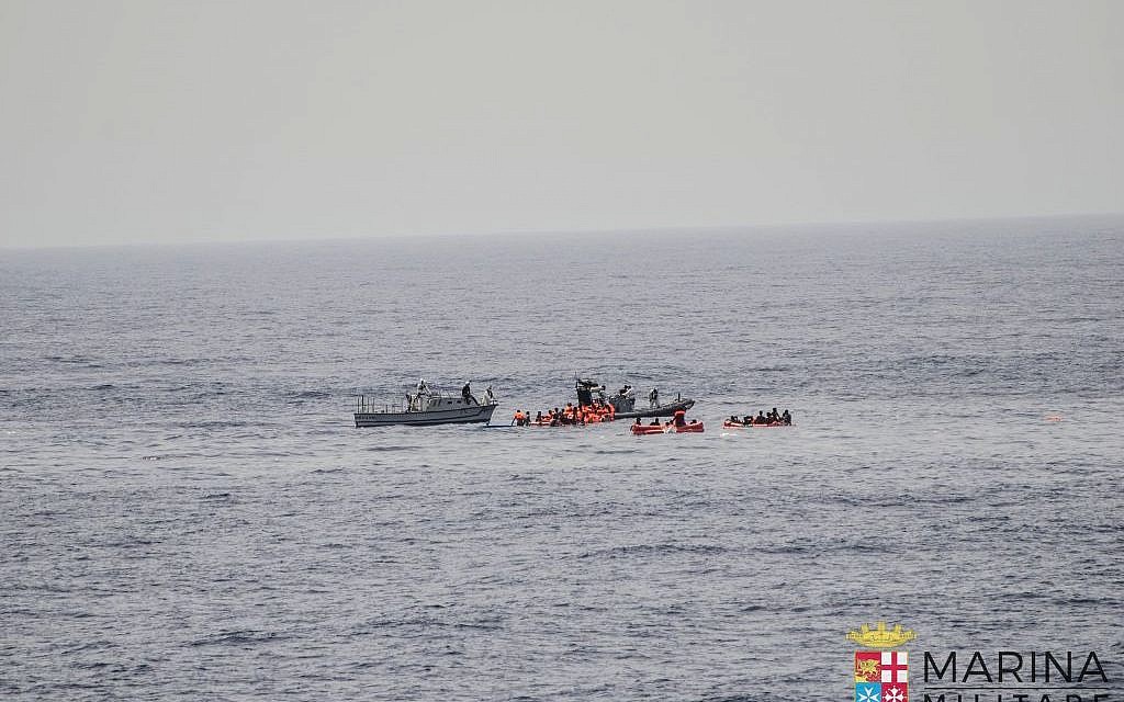 Rescuers help migrants board rubber dinghies before towing them to the Italian Navy ship Vega, May 27, 2016. (Raffaele Martino/Marina Militare via AP Photo)