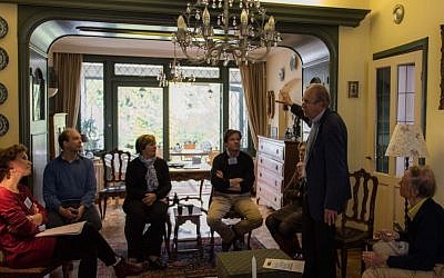 Kees van den Heuvel, standing, talking to guests about the Jewish family that once lived in what is now his home in the Netherlands town of Vught, April 30, 2016. (Cnaan Liphshiz)