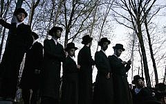 Illustrative: Hasidic Jews trying to see the burial of Rabbi Moses Teitelbaum in the upstate New York village of Kiryas Joel, April 25, 2006. (Stephen Chernin/Getty Images via JTA)