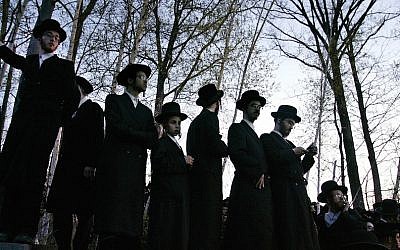Illustrative: Hasidic Jews trying to see the burial of Rabbi Moses Teitelbaum in the upstate New York village of Kiryas Joel, April 25, 2006. (Stephen Chernin/Getty Images via JTA)