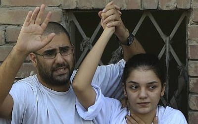 Prominent Egyptian blogger Alaa Abdel-Fattah, left, with his sister Sanaa Abdel-Fattah, speaks to the crowd after attending their father's funeral in Cairo, Egypt, Aug. 28, 2014. (AP Photo/Hassan Ammar)