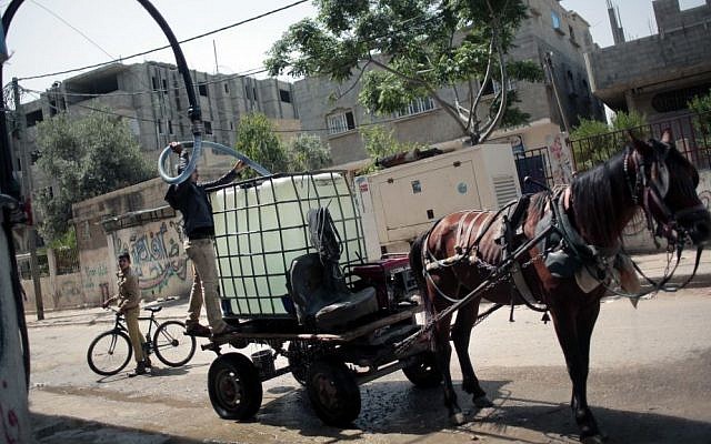 In this Saturday, April 16, 2016 photo, A Palestinian man fills a water tank on his horse cart with drinking water for sale from a water station in the Khan Younis refugee camp, southern Gaza Strip. (AP Photo/Khalil Hamra) In this Saturday, April 16, 2016 photo, A Palestinian man fills a water tank on his horse cart with drinking water for sale from a water station in the Khan Younis refugee camp, southern Gaza Strip. (AP Photo/Khalil Hamra)