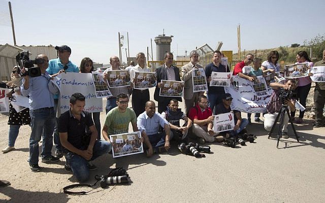 Palestinian journalists hold banners during a protest calling for the release of Palestinian journalist Omar Nazzal, April 26, 2016. (AP Photo/Majdi Mohammed)