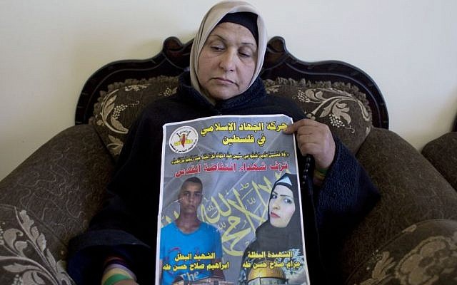 Palestinian Fatema Taha, 40, the mother of Maram, 24 and Ibrahim Taha, 16, displays a poster with their pictures and Arabic that reads, "Islamic Jihad in Palestine celebrates the martyrs of Jerusalem's uprising," at the family house, in the West Bank village of Qatana, near Ramallah, Thursday, April 28, 2016. (AP Photo/Nasser Nasser) Palestinian Fatema Taha, 40, the mother of Maram, 24 and Ibrahim Taha, 16, displays a poster with their pictures and Arabic that reads, "Islamic Jihad in Palestine celebrates the martyrs of Jerusalem's uprising," at the family house, in the West Bank village of Qatana, near Ramallah, Thursday, April 28, 2016. (AP Photo/Nasser Nasser)