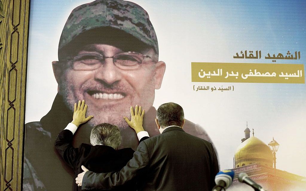 Adnan Badreddine, left, brother of Hezbollah terror chief Mustafa Badreddine, grieves at his brother's picture in a southern suburb of Beirut, Lebanon, Friday, May 13, 2016. (AP Photo/Hassan Ammar)