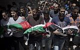 Palestinian mourners carry the bodies of three children who were killed in a fire caused by a candle, during their funeral in the Shati refugee camp in Gaza City, Saturday, May 7, 2016. (AP Photo/ Khalil Hamra)