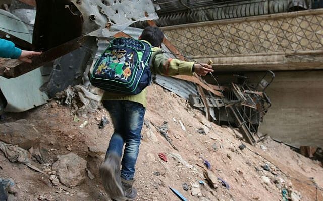 In this Thursday, Feb. 11, 2016 file photo, a child navigates rubble and barbed wire in Aleppo, Syria. (Alexander Kots/Komsomolskaya Pravda via AP, File)