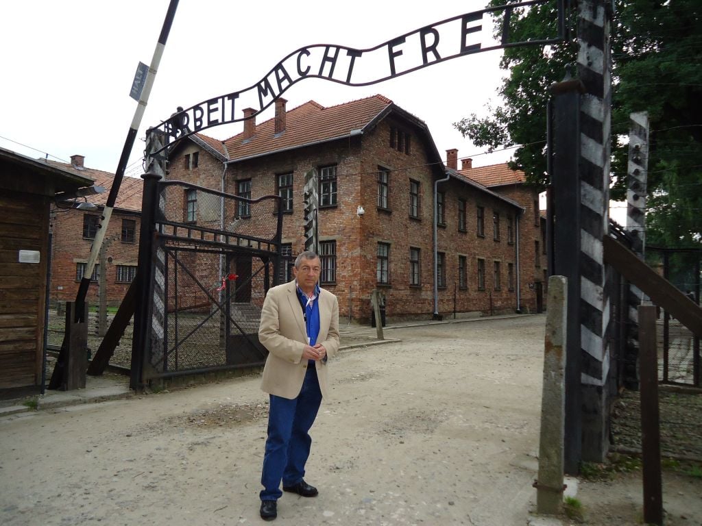 Filmmaker Philippe Mora beneath the infamous entrance to Auschwitz, 2011. The film 'Three Days in Auschwitz' is about three visits Mora made to the camp (courtesy) Filmmaker Philippe Mora beneath the infamous entrance to Auschwitz, 2011. The film 'Three Days in Auschwitz' is about three visits Mora made to the camp (courtesy)