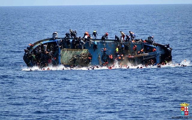 People jump off a boat moments before it overturns off the Libyan coast, Wednesday, May 25, 2016. (Marina Militare via AP) People jump off a boat moments before it overturns off the Libyan coast, Wednesday, May 25, 2016. (Marina Militare via AP)