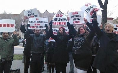 Orthodox activists, like these protesting outside a Brooklyn yeshiva on May 3, 2016, are asking institutions to do more to report and investigate allegations of child sexual and physical abuse. (Courtesy of Chaim Levin via JTA)