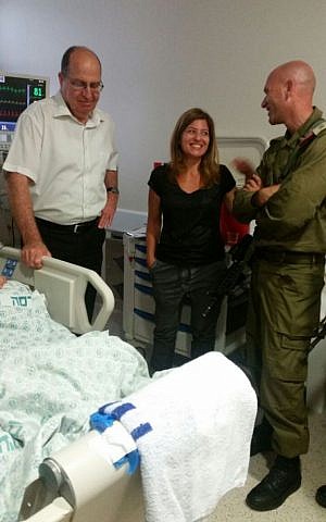 From left, defense minister Moshe Ya'alon, Ayelet Roditi, mother of Shahar Roditi, and Roditi's commanding officer visiting the injured soldier in the hospital May 15, 2016. (courtesy)
