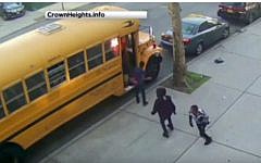 An image taken from security camera footage shows young men setting a bus  on fire in the Beis Rivkah elementary school in Crown Heights, Brooklyn, New York on April 8, 2016. (screen capture: YouTube)