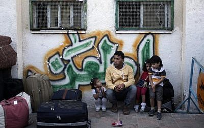 A Palestinian family sit next to their luggage as they wait for their turn to enter the Rafah border crossing with Egypt, in the southern Gaza Strip, May 11, 2016. (AP Photo/ Khalil Hamra)
