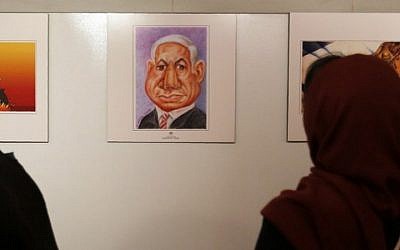 An Iranian woman looks at an anti-Israel cartoon of Prime Minister Benjamin Netanyahu at the second international exhibition of drawing and cartoons on the Holocaust in Tehran on May 14, 2016 (AFP PHOTO / ATTA KENARE)