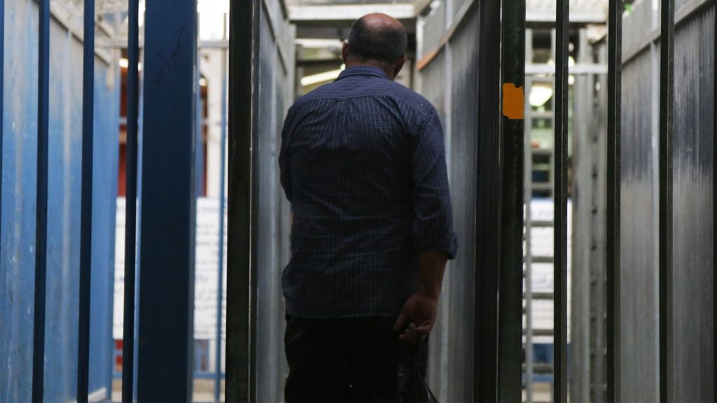 Photo taken from the Qalandiya Crossing on May 3, 2016, shows a Palestinian laborer entering the metal "sleeve" where all crossers must path through before having their IDs checked (Luke Tress / Times of Israel). Photo taken from the Qalandiya Crossing on May 3, 2016, shows a Palestinian laborer entering the metal "sleeve" where all crossers must path through before having their IDs checked (Luke Tress / Times of Israel).