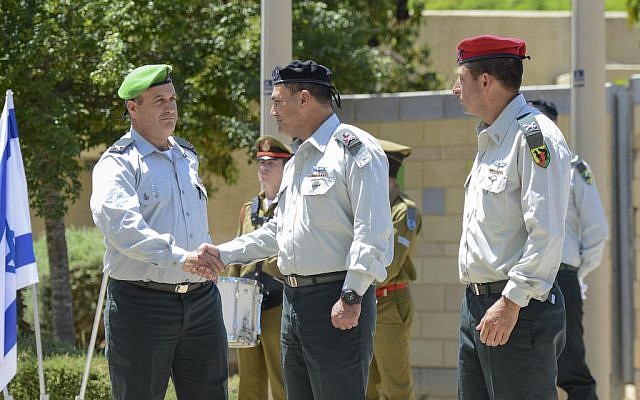 Incoming head of the Gaza Division Brig. Gen. Yehuda Fuchs, left, shakes hands with Southern Command chief Maj. Gen. Eyal Zamir during a ceremony marking the exit of Brig. Gen. Itay Virov, right, from the position, at the division's base near the Gaza border on May 19, 2016. (IDF Spokesperson's Unit)