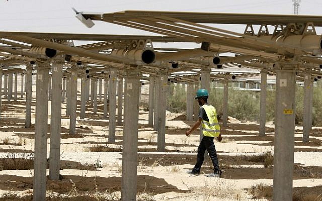 A worker walking past some of the 55,000 mirrors directing sunlight toward the Ashalim solar tower during construction, near the southern Israeli kibbutz of Ashalim in the Negev desert, May 26, 2016. (Jack Guez/AFP) A worker walking past some of the 55,000 mirrors directing sunlight toward the Ashalim solar tower during construction, near the southern Israeli kibbutz of Ashalim in the Negev desert, May 26, 2016. (Jack Guez/AFP)