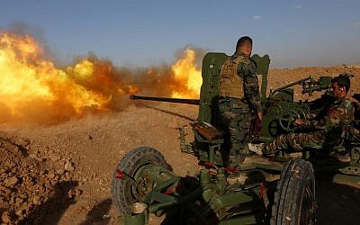 Iraqi Kurdish Peshmerga fighters fire an anti-tank cannon on the front line near Hasan Sham village, some 45 kilometers east of the city of Mosul, during an operation aimed at retaking areas from the Islamic State group on May 29, 2016. (AFP PHOTO / SAFIN HAMED)