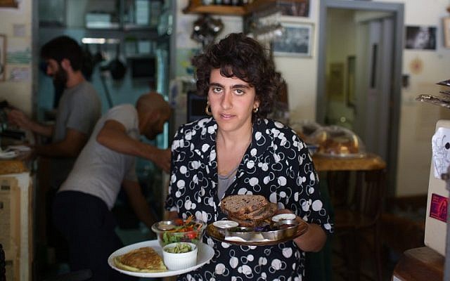 A waitress serves foos at the Carousela restaurant, which was supervised by Hashgaha Pratit - Hebrew for private supervision - to check it abides by kosher practices, on June 8, 2016, in Jerusalem's Rehavia neighborhood.(AFP PHOTO / MENAHEM KAHANA)