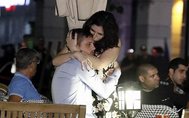 Israelis embrace following a shooting attack at a shopping complex in the Mediterranean coastal city of Tel Aviv on June 8, 2016. (AFP PHOTO / JACK GUEZ)