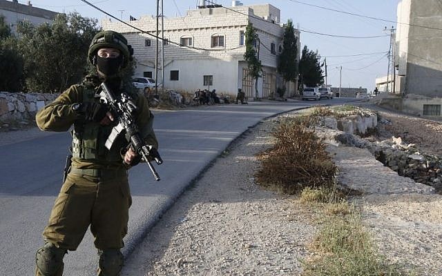 An Israel soldier at the entrance of the Palestinian town of Yatta in the West Bank on June 9, 2016. (AFP/HAZEM BADE)