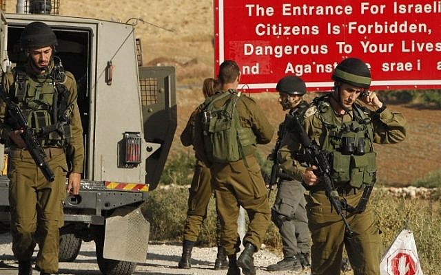 Soldiers are seen at one of the entrances of the Palestinian village of Yatta, near Hebron, on June 9, 2016 (AFP/Hazem Bader) Soldiers are seen at one of the entrances of the Palestinian village of Yatta, near Hebron, on June 9, 2016 (AFP/Hazem Bader)