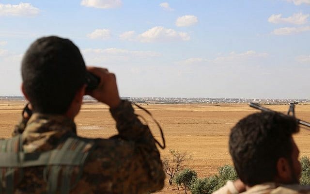 Fighters from the Syrian Democratic Forces use binoculars from a viewpoint overlooking the northern Syrian town of Manbij held by the Islamic State group as they encircle the town cutting off the jihadists' main supply route between Syria and Turkey on June 10, 2016. (AFP PHOTO/DELIL SOULEIMAN) Fighters from the Syrian Democratic Forces use binoculars from a viewpoint overlooking the northern Syrian town of Manbij held by the Islamic State group as they encircle the town cutting off the jihadists' main supply route between Syria and Turkey on June 10, 2016. (AFP PHOTO/DELIL SOULEIMAN)