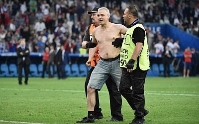 A Russia supporter is escorted by stewards following the Euro 2016 group B football match between England and Russia at the Stade Velodrome in Marseille on June 11, 2016. (AFP PHOTO/BERTRAND LANGLOIS)