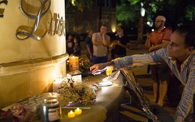 Mourners light candles at the Legacy of Love statue during a vigil in Dallas, Texas, on June 12, 2016, for victims of the attack at Orlando's Pulse Nightclub in Orlando, Florida. (AFP/Laura Buckman)