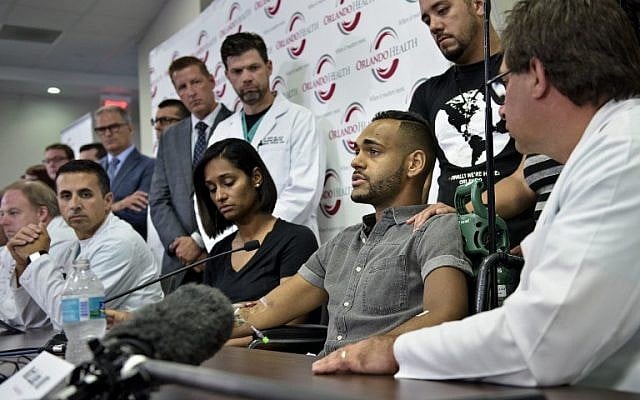 Angel Colon (3rd-R), a survivor of the Pulse nightclub mass shooting, speaks during a press conference with Orlando Health trauma staff at Orlando Regional Medical Center June 14, 2016 in Orlando, Florida. AFP PHOTO / Brendan Smialowski)