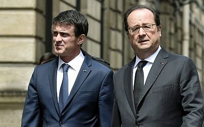 French Prime Minister Manuel Valls (L), and French President Francois Hollande (R), walk back to the Elysee palace on June 15, 2016, in Paris after a ceremony at the Ministry of Interior to pay a tribute to a French policeman and his partner, who were killed on June 13 by a man claiming allegiance to the Islamic State group. (AFP PHOTO / ALAIN JOCARD)