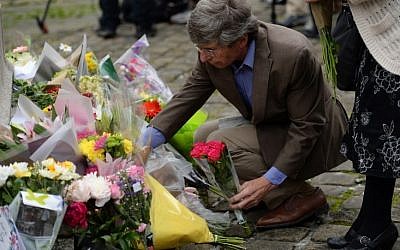 People lay floral tributes to slain Labour MP Jo Cox, at the base of a statue to Joseph Priestley in Birstall, northern England, on June 17, 2016, near to the scene where she was shot yesterday. (AFP PHOTO / OLI SCARFF)
