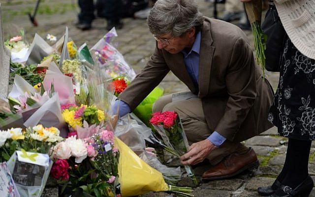 People lay floral tributes to slain Labour MP Jo Cox, at the base of a statue to Joseph Priestley in Birstall, northern England, on June 17, 2016, near to the scene where she was shot yesterday. (AFP PHOTO / OLI SCARFF)