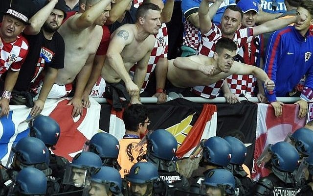 Croatia fans react as French riot police look up at them after flares were thrown onto the pitch during the Euro 2016 group D football match between Czech Republic and Croatia at the Geoffroy-Guichard stadium in Saint-Etienne on June 17, 2016. (AFP/ JEAN-PHILIPPE KSIAZEK) Croatia fans react as French riot police look up at them after flares were thrown onto the pitch during the Euro 2016 group D football match between Czech Republic and Croatia at the Geoffroy-Guichard stadium in Saint-Etienne on June 17, 2016. (AFP/ JEAN-PHILIPPE KSIAZEK)