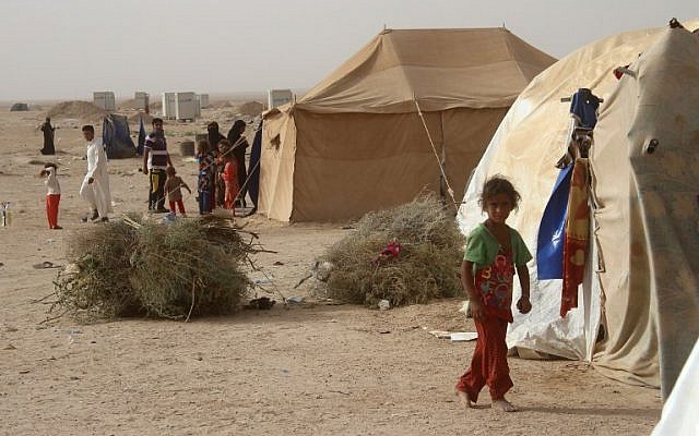 Displaced Iraqis from the embattled city of Fallujah stand outside tents where they are taking shelter some 18 kilometers from Ramadi on June 18, 2016. ( AFP PHOTO / MOADH AL-DULAIMI)
