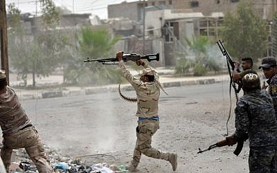 Iraqi government forces clash with Islamic State (IS) group fighters in Fallujah on June 18, 2016 as they hunt down holdout jihadists after retaking the city which was IS's last remaining major hub in Iraq. (AFP/STRINGER)