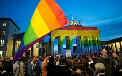 People gather in front of the Brandenburg Gate, illuminated in rainbow colors, to pay tribute to the victims of the Orlando killing, in Berlin, Germany, on June 18, 2016. (Jörg Carstensen/dpa/AFP)