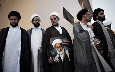Bahraini Shiite clerics attend a protest against the revocation of the citizenship of top Bahraini Shiite cleric Sheikh Isa Qassim (portrait), near his house in the village of Diraz, west of the capital Manama,  June 20, 2016. (AFP/MOHAMMED AL-SHAIKH)