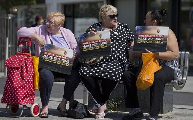 Leave supporters holds placards as they sit in Clacton-on-Sea as UK Independence Party (UKIP) leader Nigel Farage visits on June 21, 2016.(AFP PHOTO / JUSTIN TALLIS)