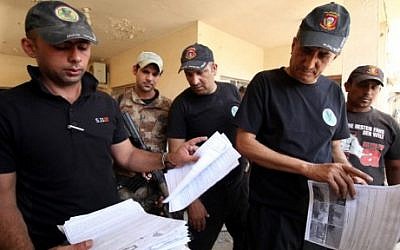 Members of the Iraqi counter-terrorism forces inspect documents in a building formerly used as a home-made bomb making factory by Islamic State (IS) group fighters in the northern Shurta neighbourhood of Fallujah as they patrol the city clearing roadside bombs and booby-traps on June 23, 2016. (AFP PHOTO / HAIDAR MOHAMMED ALI)