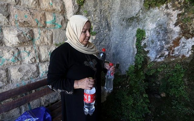 A member of the Salim family carries bottles filled with spring water on June 23, 2016 in Salfit, north of Ramallah (AFP PHOTO / JAAFAR ASHTIYEH) A member of the Salim family carries bottles filled with spring water on June 23, 2016 in Salfit, north of Ramallah (AFP PHOTO / JAAFAR ASHTIYEH)